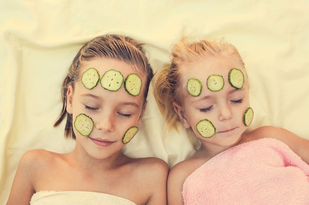 Photo beautiful girl with facial mask of cucumber. toned image