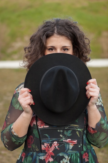 Beautiful girl with flowered dress an black hat