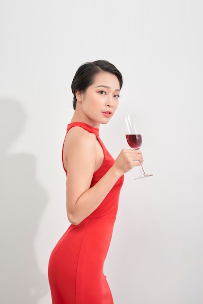 Beautiful girl with glass of champagne celebrating. Portrait of smiling young woman with stylish hairstyle, sexy glamour makeup on beauty face with drink. High quality image