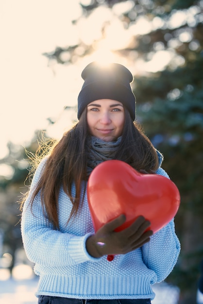 Beautiful girl with heart shaped balloon in hands, Valentine's Day