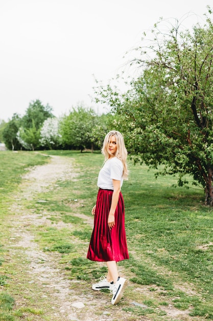 Beautiful girl with light hair, glasses, near flowering trees, Apple tree, spring, branches, flower, fashion, style, European, red