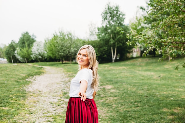 Beautiful girl with light hair, glasses, near flowering trees, Apple tree, spring, branches, flower, fashion, style, European, red