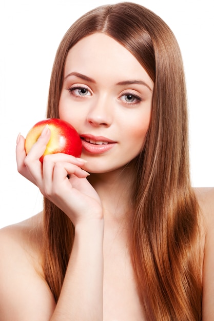 Beautiful girl with long brown hair holding apple