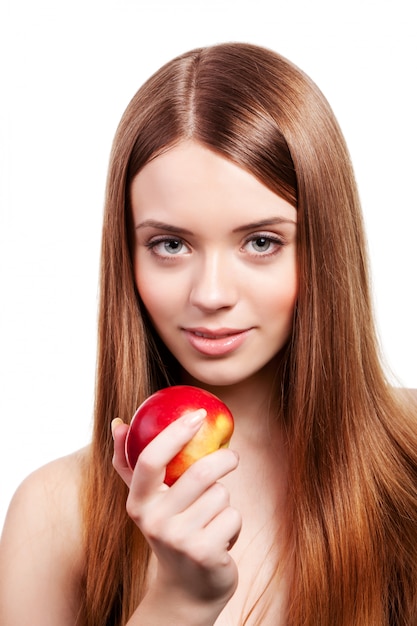 Beautiful girl with long brown hair holding apple