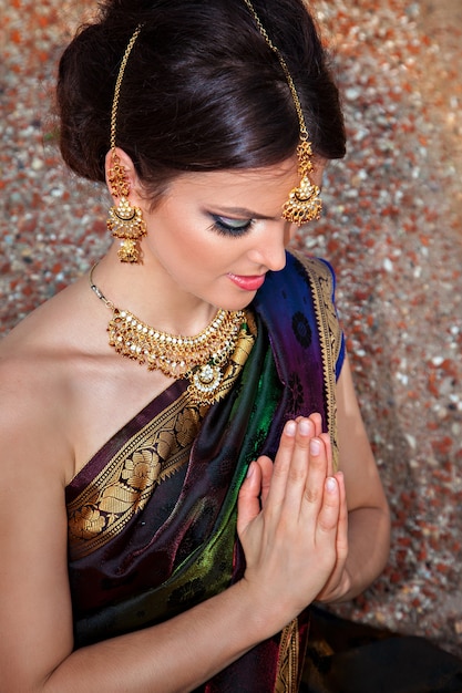 Beautiful girl with oriental make-up, indian sari and indian jewelry