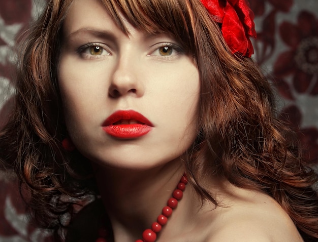 Beautiful girl with red flower in hair