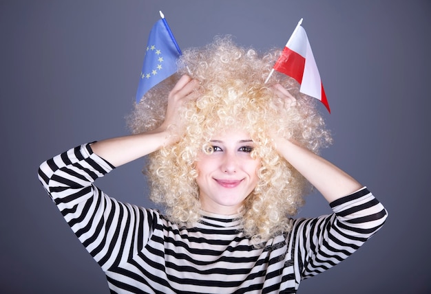 Photo beautiful girl with ringlets show european union and poland flag.