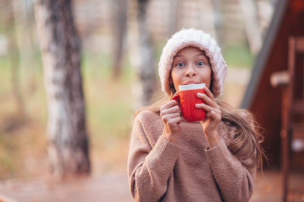 Beautiful girl wrapped in a blanket at autumn warm day