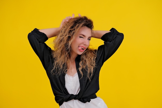 Beautiful girl on a yellow background Pretty brave woman showing wild devilish side making bull horns with her fingers on her head