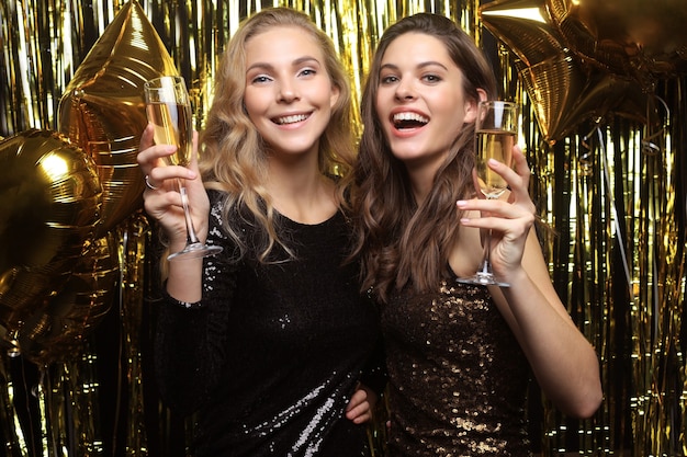 Beautiful girls celebrating New Year. Gorgeous smiling young women enjoying party celebration, having fun together.