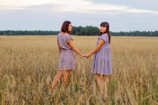 Beautiful girls in a field with wheat Milk and bread Peacetime Happiness Love Two sisters Girlfriends