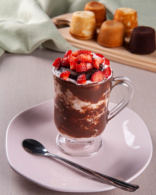 Beautiful glass of vanilla ice cream with chocolate cake and strawberry fruit on top