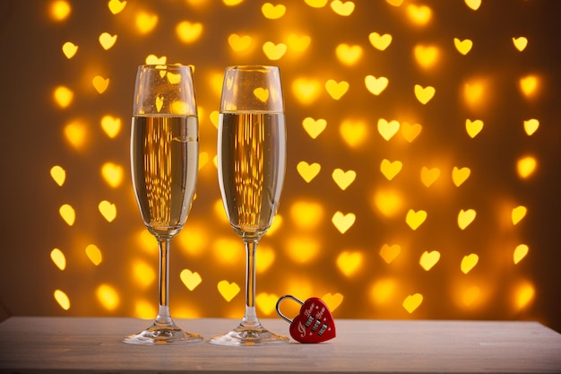 Beautiful glasses of champagne on a blurred background of hearts