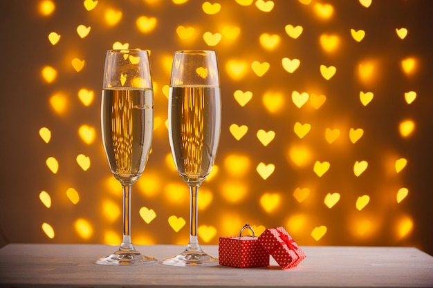 Beautiful glasses of champagne on a blurred background of hearts