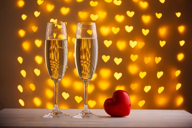 Beautiful glasses of champagne on a blurred background of hearts