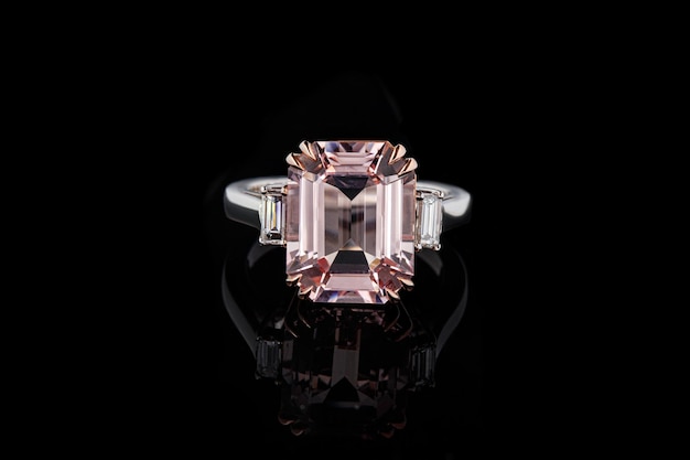 Beautiful gold ring with morganite and diamond gemstones on a black background