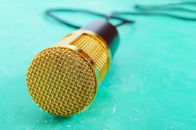 Beautiful golden microphone on a bright background, copy space, close up, bokeh.