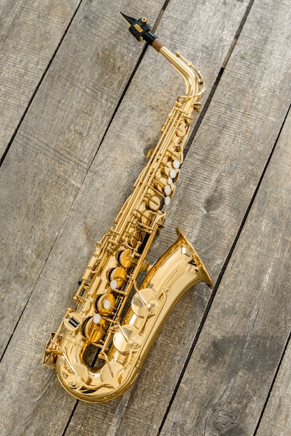 Beautiful golden saxophone on wooden background