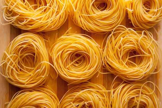 Photo beautiful golden three pasta raw yellow nests, bio raw food