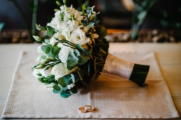 Beautiful golden wedding rings with flowers on a burlap background Mens wedding ring Women's ring