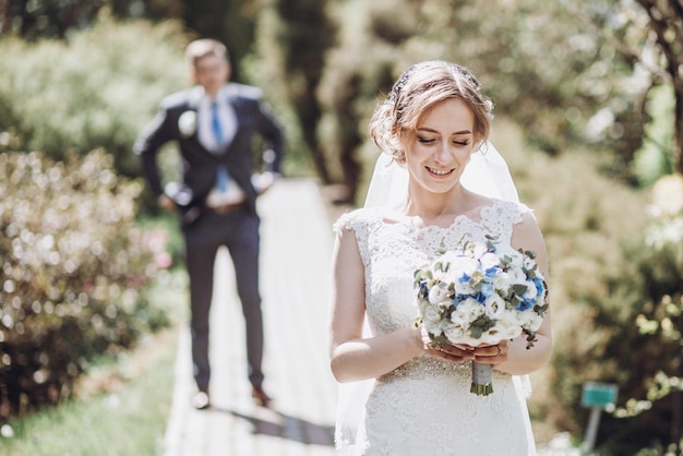 Beautiful gorgeous bride and groom walking in sunny spring park and enjoying day happy wedding couple relaxing in green garden happy marriage moments elopement concept