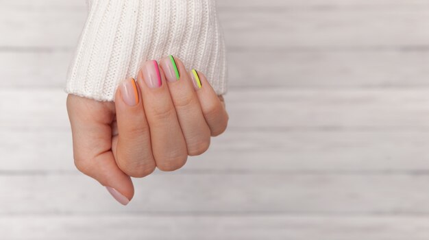 Beautiful groomed woman's hands with colored nails