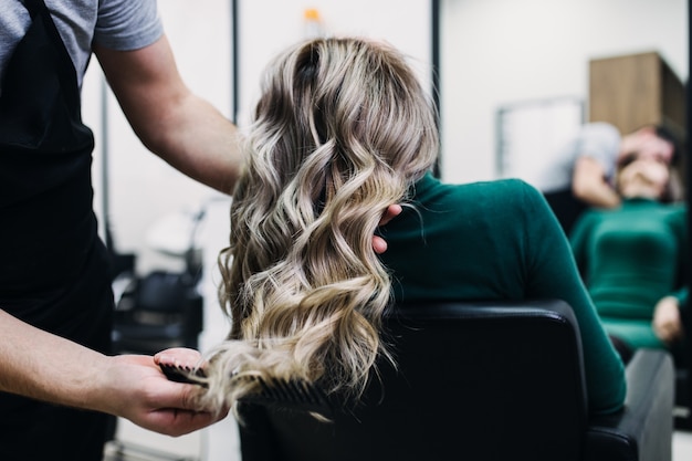 Beautiful hairstyle of mature woman after dying hair and making highlights in hair salon.