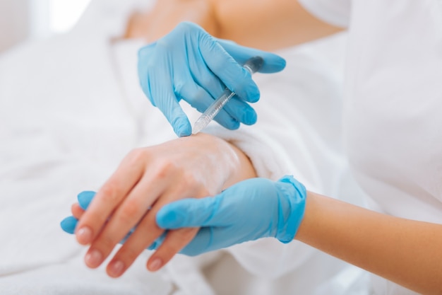 Beautiful hands. Beauty injection being done in the female hand during a procedure in the beauty salon