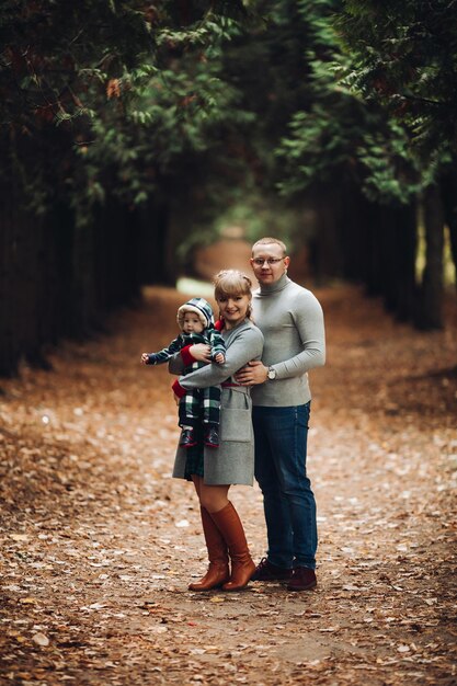 Beautiful and happy family with little child in park