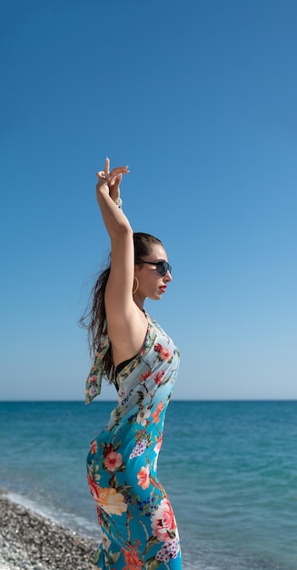 Beautiful and happy girl on the sea of the sea in bright stylish summer clothes