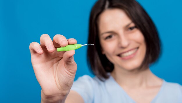 Beautiful happy young woman using interdental brush