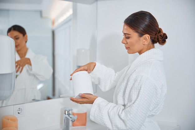 Beautiful healthy smiling caucasian woman taking care of her skin in the bathroom