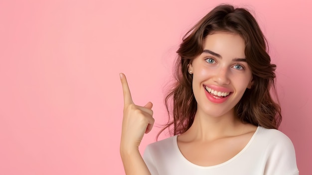 Beautiful healthy young woman smiling with her finger pointing and looking at a light pink