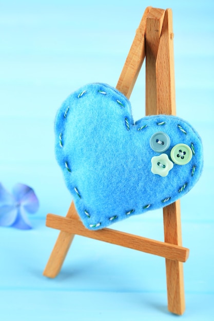 Beautiful heart  small decorative easel on blue background