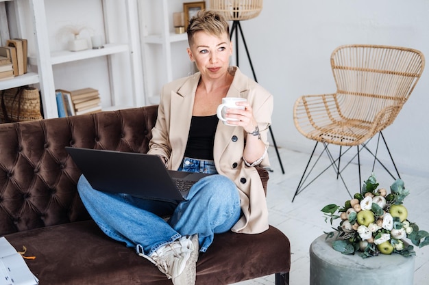 Beautiful hipster woman in casual cloth using laptop at home cheerful woman using laptop