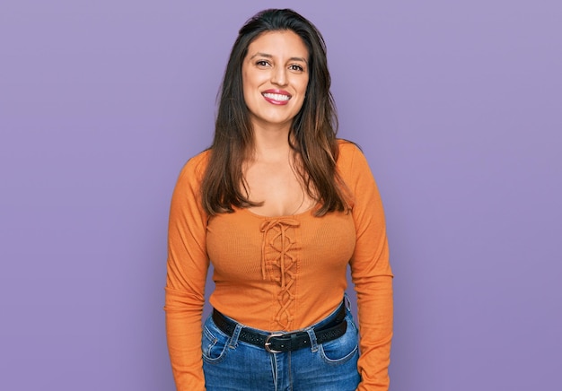 Beautiful hispanic woman wearing casual clothes looking positive and happy standing and smiling with a confident smile showing teeth