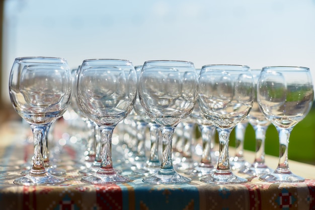 Beautiful holiday table glasses of wine glassestwo rows of glasses on a table with a white tableclothglasses on high legsplaced a glass of wine on festive table