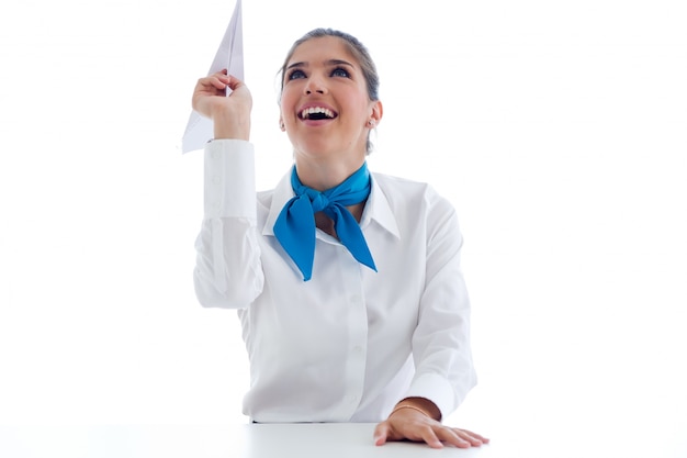 Beautiful hostess holding paper airplane. Isolated on white.