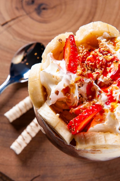 Beautiful ice cream bowl decorated with strawberries bananas chestnuts and whipped cream