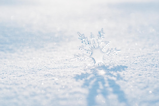 Beautiful ice crystal lies in the snow and glistens in the sun bokeh in the blue background