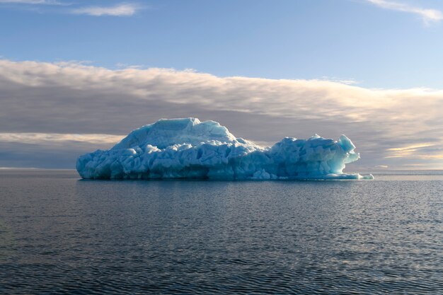 Beautiful iceberg in Arctic sea at sunny day. Big piece of ice in sea close up.