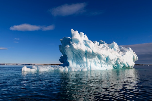 Beautiful iceberg in Arctic sea at sunny day. Big piece of ice in sea close up.