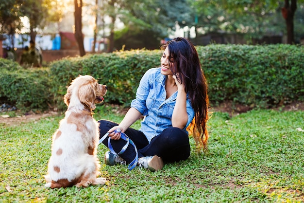 Beautiful indian girl training her cocker spaniel dog