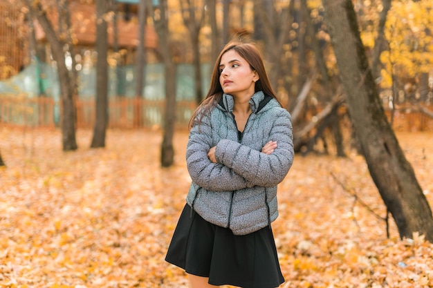 Beautiful indian woman generation z relaxing and feeling nature at autumn park in fall season copy