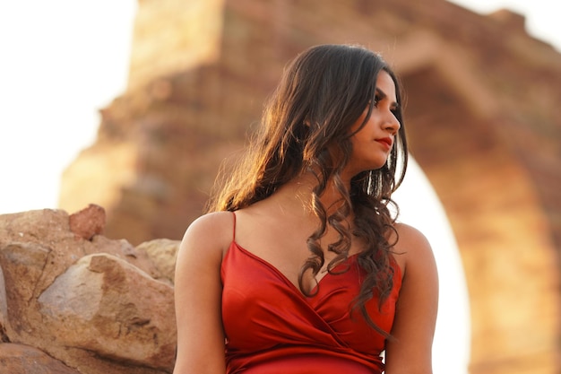 Beautiful indian woman in hot red dress looks aside