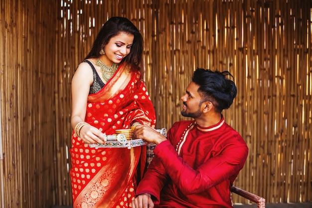 Beautiful Indian woman in a saree bringing tea to her husband in the morning