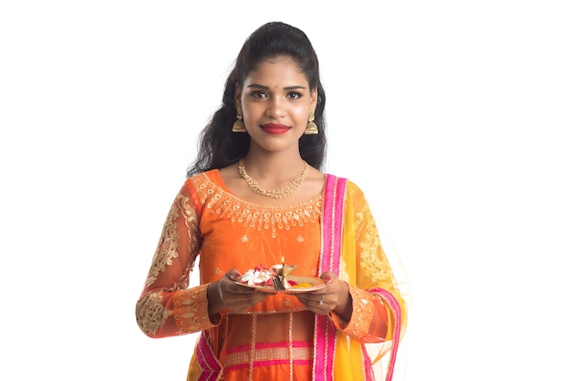 Beautiful Indian young girl holding pooja thali or performing worship