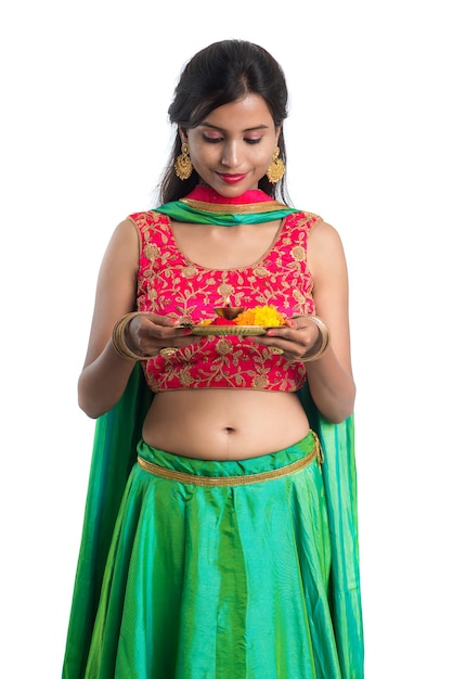 Beautiful Indian young girl holding pooja thali or performing worship