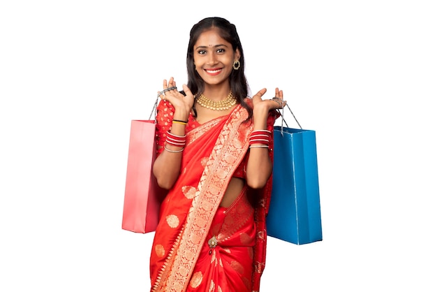 Beautiful Indian young girl holding and posing with shopping bags on a white background