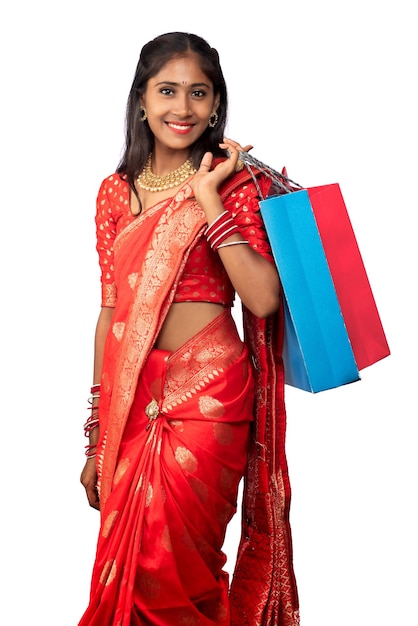 Beautiful Indian young girl holding and posing with shopping bags on a white background